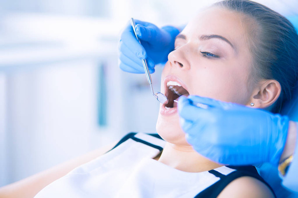 Young Female patient with open mouth examining dental inspection at dentist office. - Foto, afbeelding