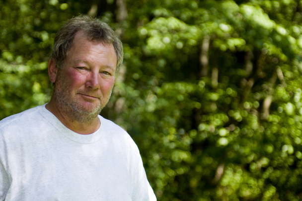 onnellinen keski-ikä mies metsäinen tausta
 - Valokuva, kuva