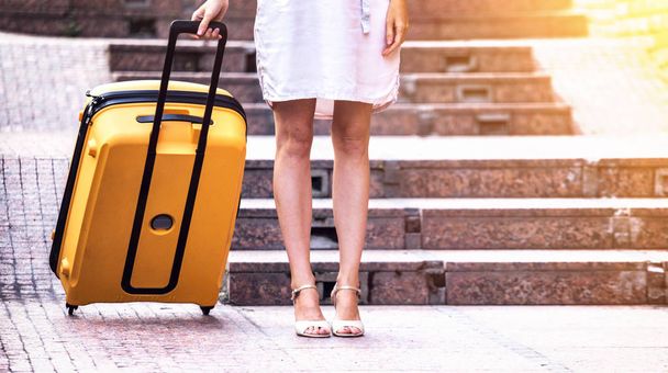 girl traveler and her yellow  luggage. wonderful trave - Фото, изображение