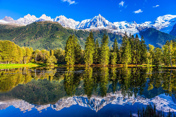  Západu slunce v Alpách. Pojem aktivní a ekoturistika. Zasněžené vrcholky Alp se odrážejí v jezeře v horském středisku Chamonix. Na úpatí Mont Blanc - Fotografie, Obrázek