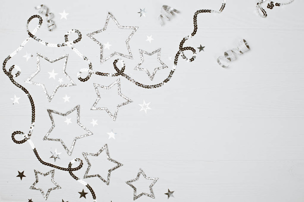 Silver sparkling stars on white wooden background. Festive holiday concept. Place for text. - Φωτογραφία, εικόνα