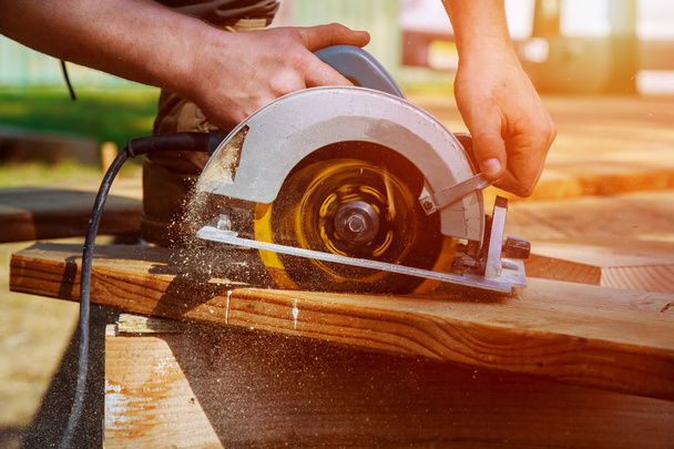 Carpintero con sierra circular para viga de madera un nuevo proyecto de construcción de viviendas - Foto, Imagen