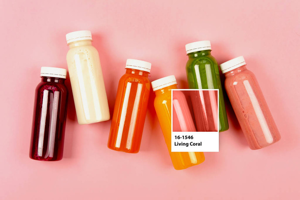 Bottles of Living Coral smoothies on geometry background. Color of the year 2019. - Valokuva, kuva