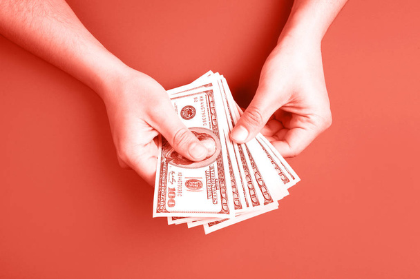 Man counting money on Living Coral background. Concept of color of the year. - Foto, Imagem