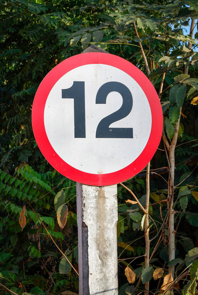 signalisation routière indiquant des restrictions pour les véhicules pesant plus de douze tonnes sur le bord de la route
 - Photo, image