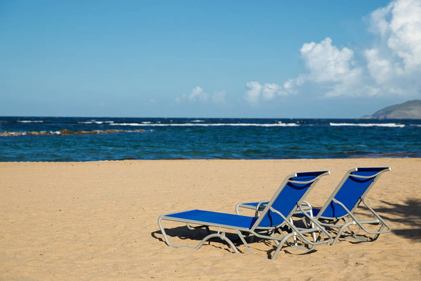 Ongerepte Caribische strand in St. Kitts met strandstoelen en oceaan achtergrond - Foto, afbeelding