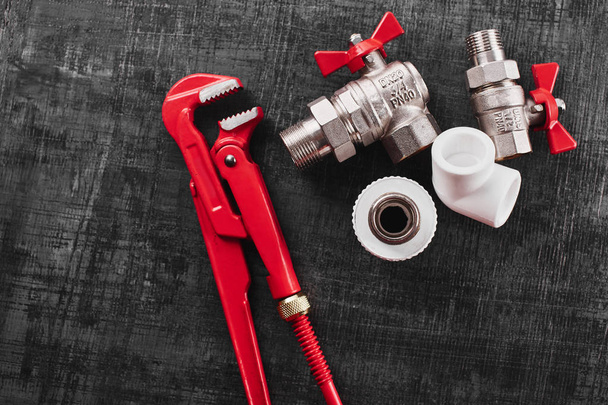 plumbing tools and equipment on a black shabby background closeup with copy space - Zdjęcie, obraz