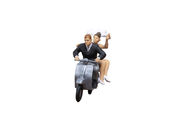 Мініатюрні люди: пара їде на мотоциклі на ізольованому білому тлі з відсічним контуром
 - Фото, зображення