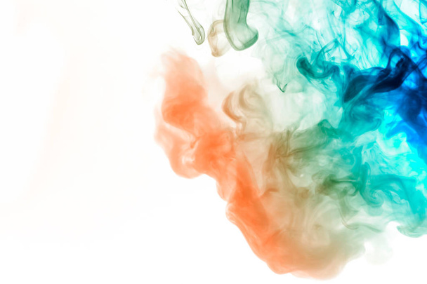 Dynamic puffs of blue gray and orange colors on a white background flow smoothly coloring waves rendering an isolated smoke pattern. Decorative wallpaper with multi-colored smoke. - Photo, Image