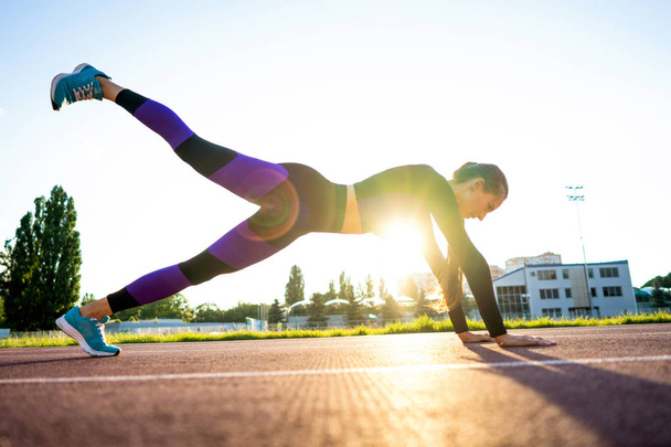 girl sportsman crossfit and run at sunset in the stadium - Foto, Imagem