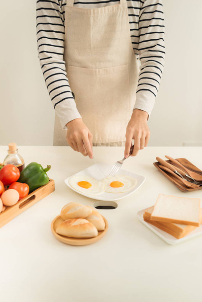 Handen van man bereiden ontbijt met eieren en brood. - Foto, afbeelding