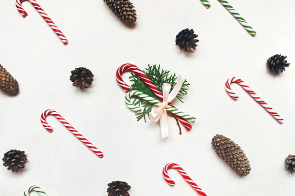 White wooden background with red and green christmas candies and conifer cones - Photo, Image