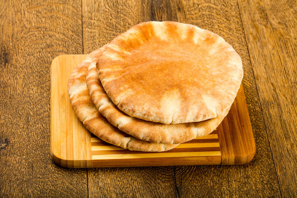 Pita chléb haldy přes dřevěné pozadí - Fotografie, Obrázek