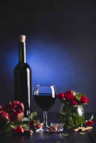 Red wine in a glass. Romantic evening with a glass of wine to Valentine's day.Holiday composition on a black table  and  background. - Foto, immagini