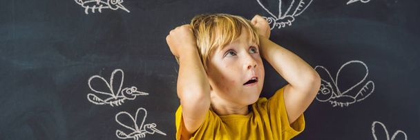 Little boy with funny facial expression and bites on face in front of blackboard with chalk drawn mosquitoes.  - Foto, Imagen