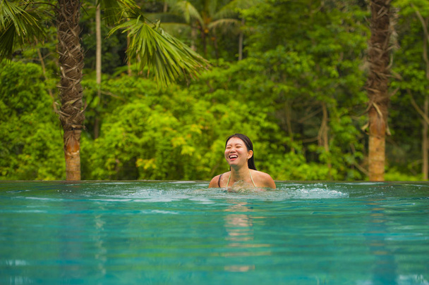 молодий привабливим і красивим, Корейська жінку розслабляючий щасливі на тропічні beach resort плавання в джунглях пейзажного басейну, насолоджуючись літній відпочинок в райський острів у подорожі призначення концепції - Фото, зображення