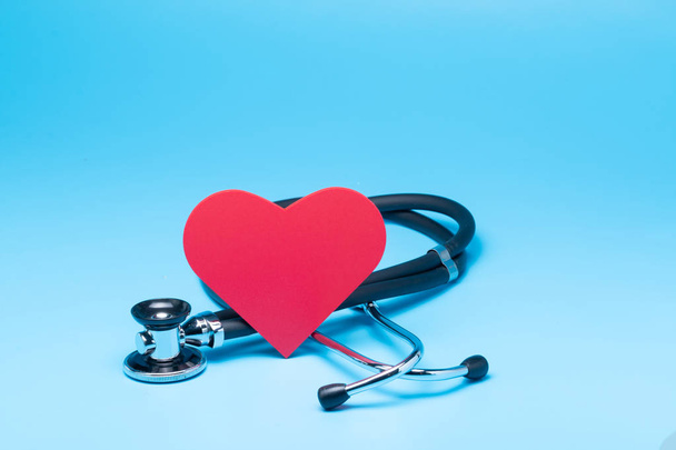 Stethoscope with red heart on blue background - Foto, afbeelding