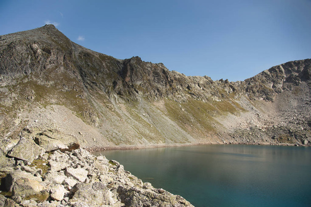 Τοπίο του highland λίμνη ψηλά στα βουνά του Dombai. Τσίρκο που σχηματίζεται από ένα παγετώνα με μια βαθιά λίμνη και μπλε νερό - Φωτογραφία, εικόνα