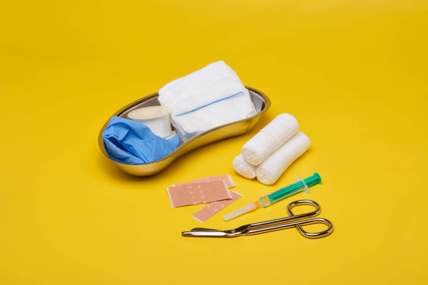 Tynki i bandaże z nożyczek i strzykawek na żółtym tle - Zdjęcie, obraz