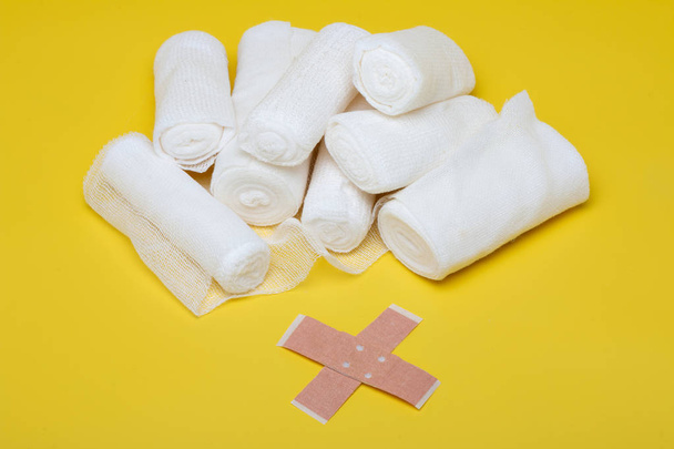 Plâtres et bandages avec ciseaux et seringue sur fond jaune
 - Photo, image