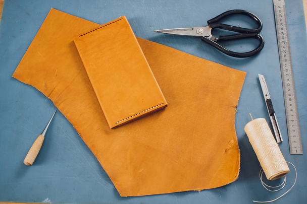 leather craftsman working making products at table in workshop studio. - Foto, afbeelding