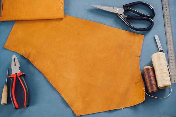 leather craftsman working making products at table in workshop studio. - Foto, Bild