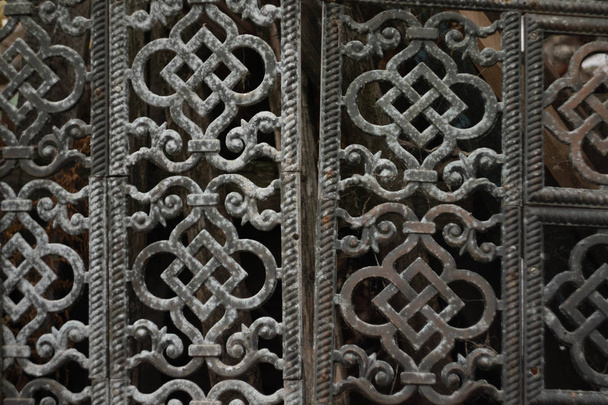 Una vieja rejilla de metal. Compuesto de placas caladas estampadas con adorno oriental. La placa gris de la antigüedad
 - Foto, imagen