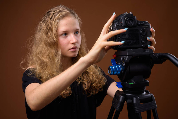 Giovane bella bionda adolescente contro sfondo marrone
 - Foto, immagini