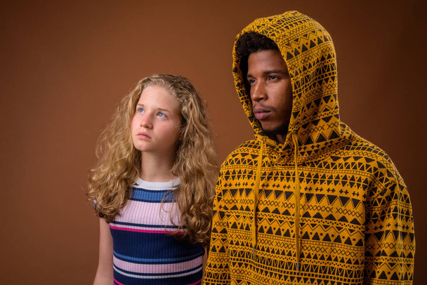 Portrait of young African man and Caucasian teenage girl thinking - Foto, Bild