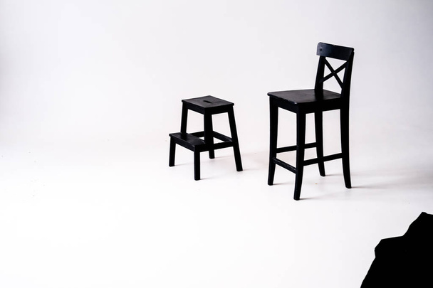 Fehér szobában, fehér alapon fekete szék  - Fotó, kép