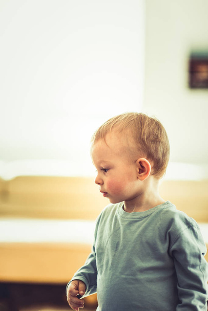 Un bébé se tient paisiblement dans son salon - Photo, image