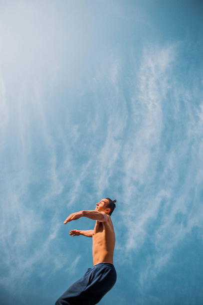Parkour guy doing tricks in the air below the sky - Foto, imagen