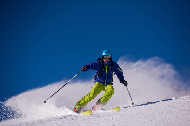 молодой спортсмен фристайл Лыжник веселится во время спуска по красивому альпийскому ландшафту в солнечный день в зимний сезон
 - Фото, изображение