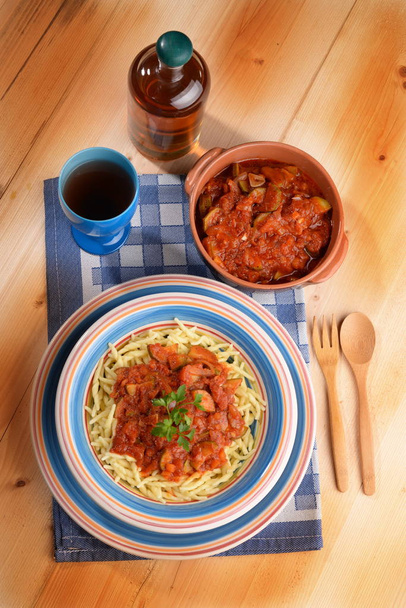 Prato de macarrão trofie com tomate com abobrinha na mesa
 - Foto, Imagem