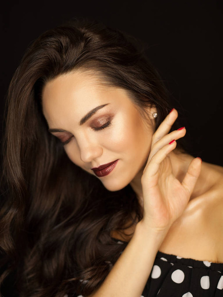Portrait de jeune femme aux cheveux foncés très attrayants avec maquillage de mode et effet peau mouillée sur fond noir
 - Photo, image