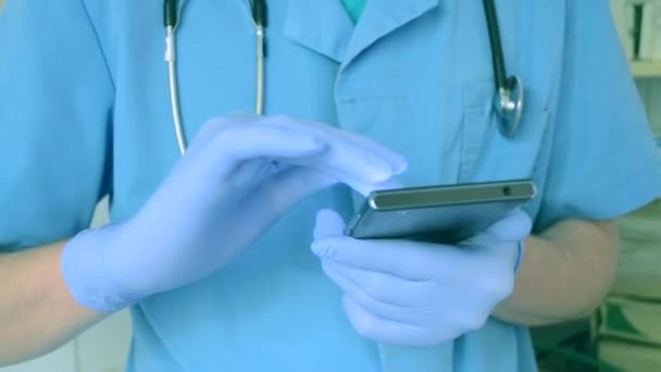 Orvos kék kesztyű, kék fut-ra egy mozgatható telefon - Felvétel, videó