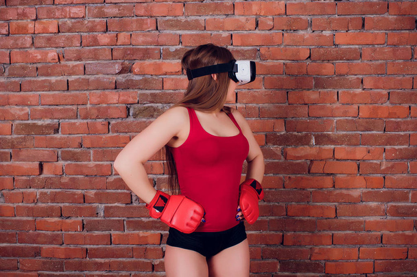Young fighter boxer fit girl in VR glasses wearing boxing gloves in training - Foto, imagen