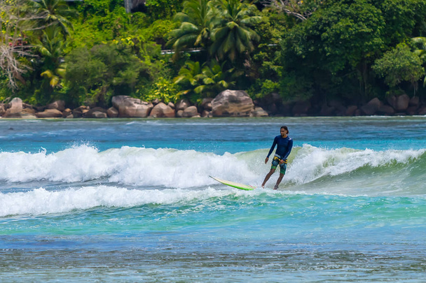 MAHE, SEYCHELLES - SEPTEMBER 25, 2018: Unidentified man surfing on a large wave on island Mahe  on the coast of Indian ocean - is the best surf paradise in Seychelles - Photo, Image