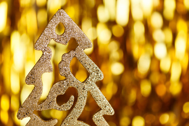 Golden Christmas tree on a gold background - Foto, afbeelding