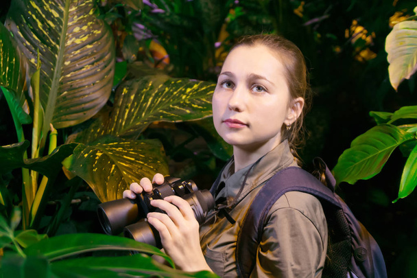 ragazza con binocolo nella giungla tra vegetazione tropicale
 - Foto, immagini