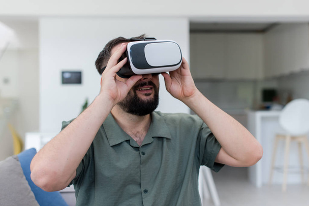 handsome hipster man with beard trying vr glasses at modern home - Foto, afbeelding