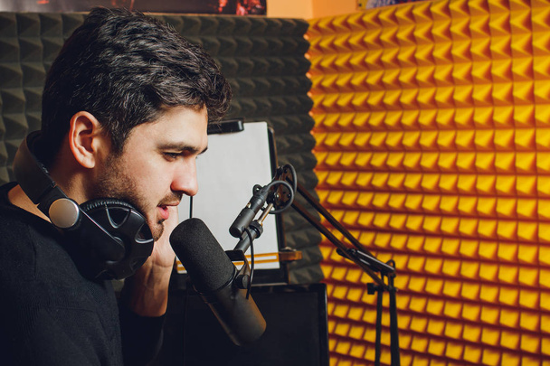 Microphone in radio studio and presenter on background. - Photo, Image