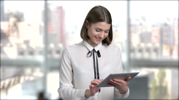 Elegante jonge vrouw met behulp van digitale tablet. Selectievakje email van de vrouw van de jonge bedrijf op de digitale tablet en glimlachend op onscherpe achtergrond. - Video