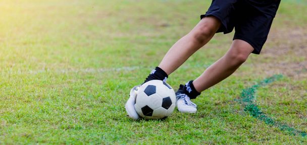 Boy soccer player speed run to shoot ball to goal on green grass. Soccer player training or football match. - Photo, Image