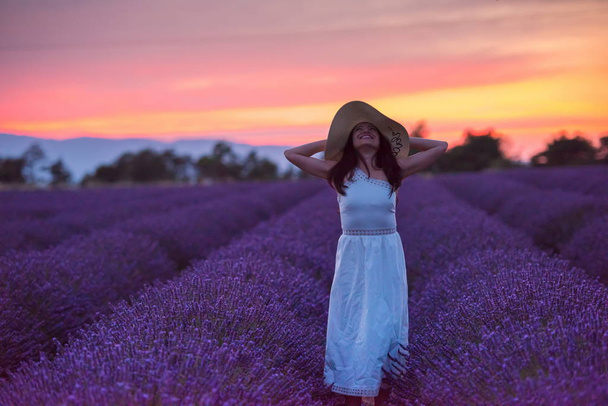 woman portrait in lavender flower fiel in sunset and night time - 写真・画像