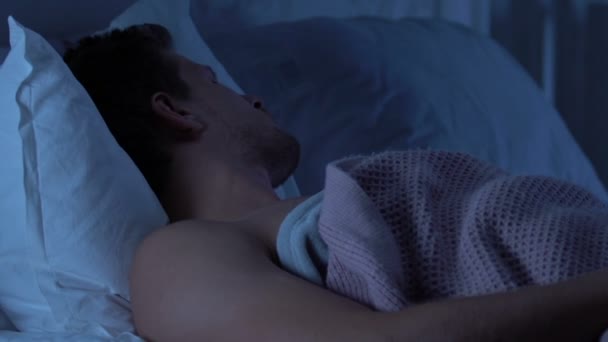 Young male having anxiety dreams, talking in sleep after long stressful workday - Video