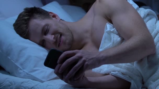 Epärehellinen mies viestii rakastajan kanssa, kun vaimo nukkuu sängyssä, petos ja valhe
 - Materiaali, video