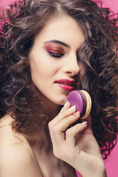 Beauty fashion model girl with colourful manicure eat colorful macaroons - Photo, image