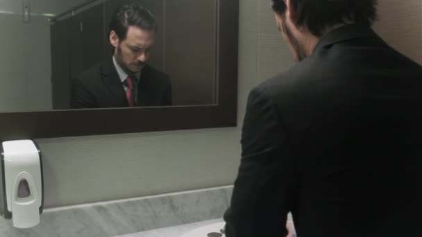 Martwi się hiszpanin biznes człowiek ogląda Hair w biurze toalety - Materiał filmowy, wideo