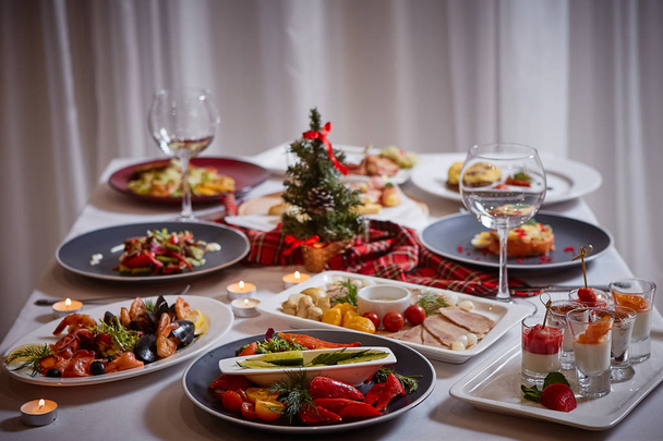 Christmas themed dinner table with a variety of appetizers and salads - Φωτογραφία, εικόνα
